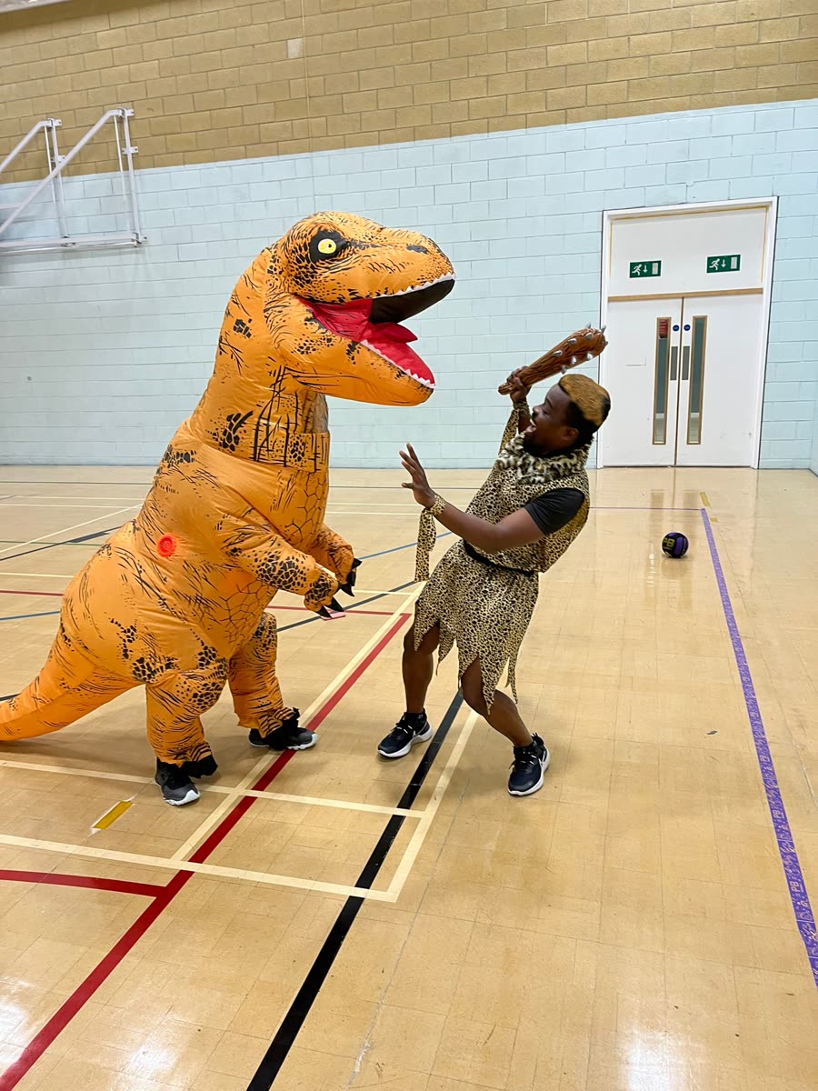 A player in an inflatable T-rex costume squaring up to one dressed as a caveman